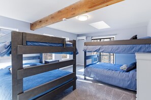 Ein Zimmer mit Etagenbetten, Deckenventilator und Fenster.