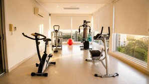 Ein Fitnessraum mit Cardiogeräten, Gewichten und einem roten Trainingsball.