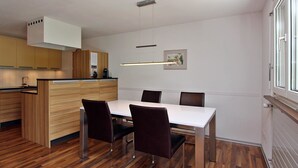 Una cocina moderna con armarios de madera, una mesa de comedor blanca y sillas.