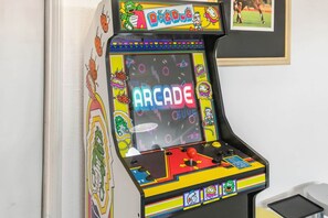 A colorful arcade machine with the word "ARCADE" on the screen, surrounded by various cartoon characters and a small photo of a soccer game.