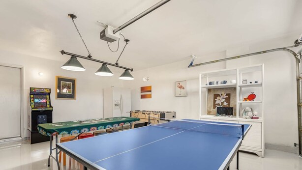 Et værelse med et pingpongbord og et bordfodboldspil.