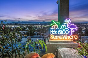 A neon sign with a flamingo and palm tree design, located on a concrete post with a cityscape in the background. - Del Mar Coastal Luxury: Minutes to Beach & Trails (Del Mar)