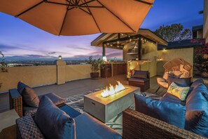A rooftop patio with outdoor furniture, a fire feature, and a view of the cityscape. - Del Mar Coastal Luxury: Minutes to Beach & Trails (Del Mar)