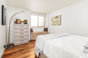 A bedroom with a bed, a dresser, a window, and a painting on the wall. - Del Mar Coastal Luxury: Minutes to Beach & Trails (Del Mar)