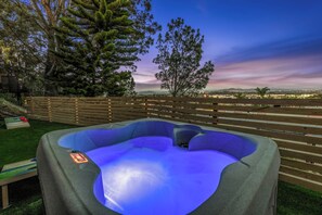 Jacuzzi amb vista a un paisatge urbà a la capvespre.