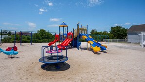 Ein Spielplatz mit mehreren Rutschen und einem Karussell.