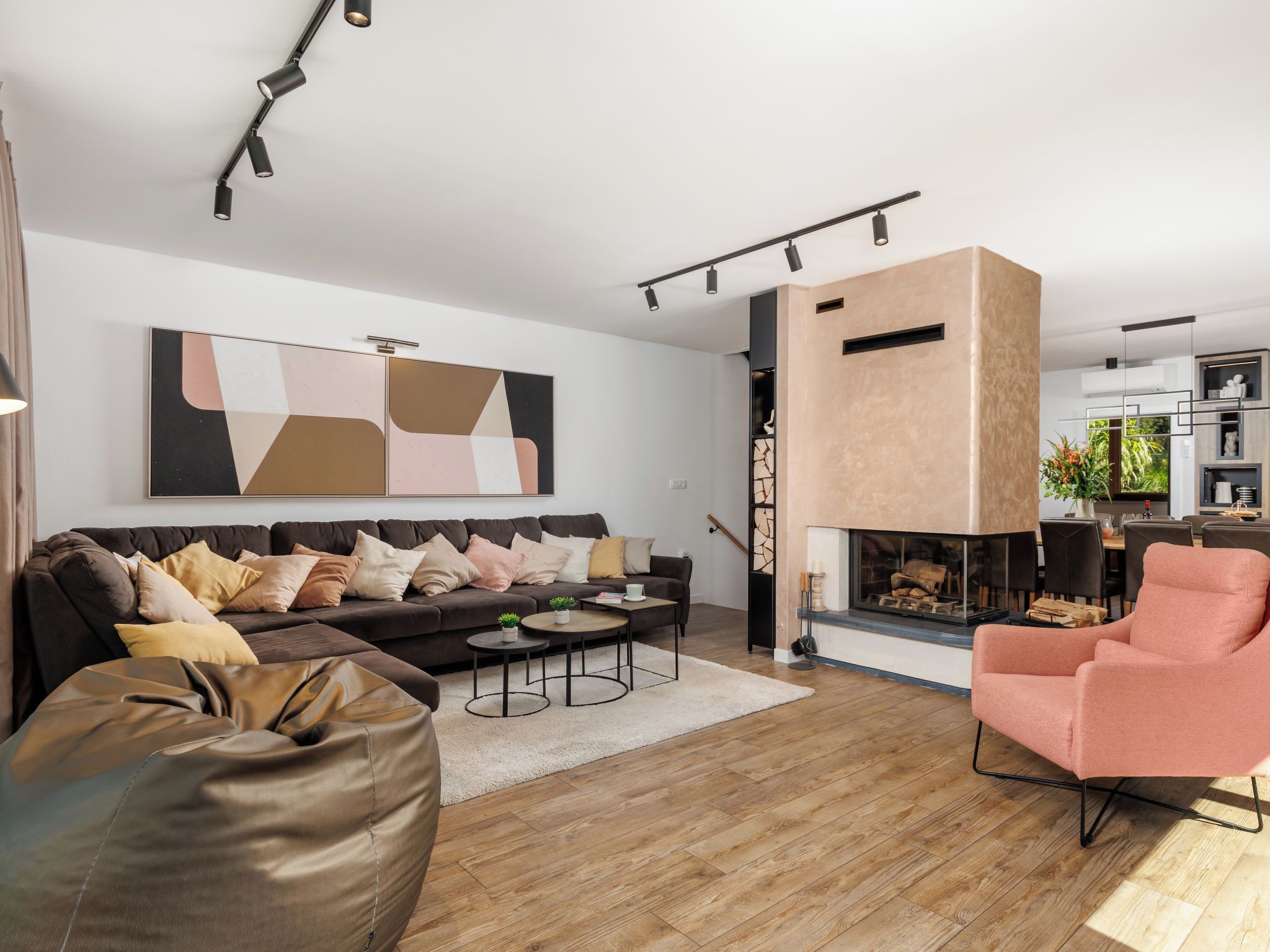A modern living room with a sofa, coffee table, and a pink armchair.