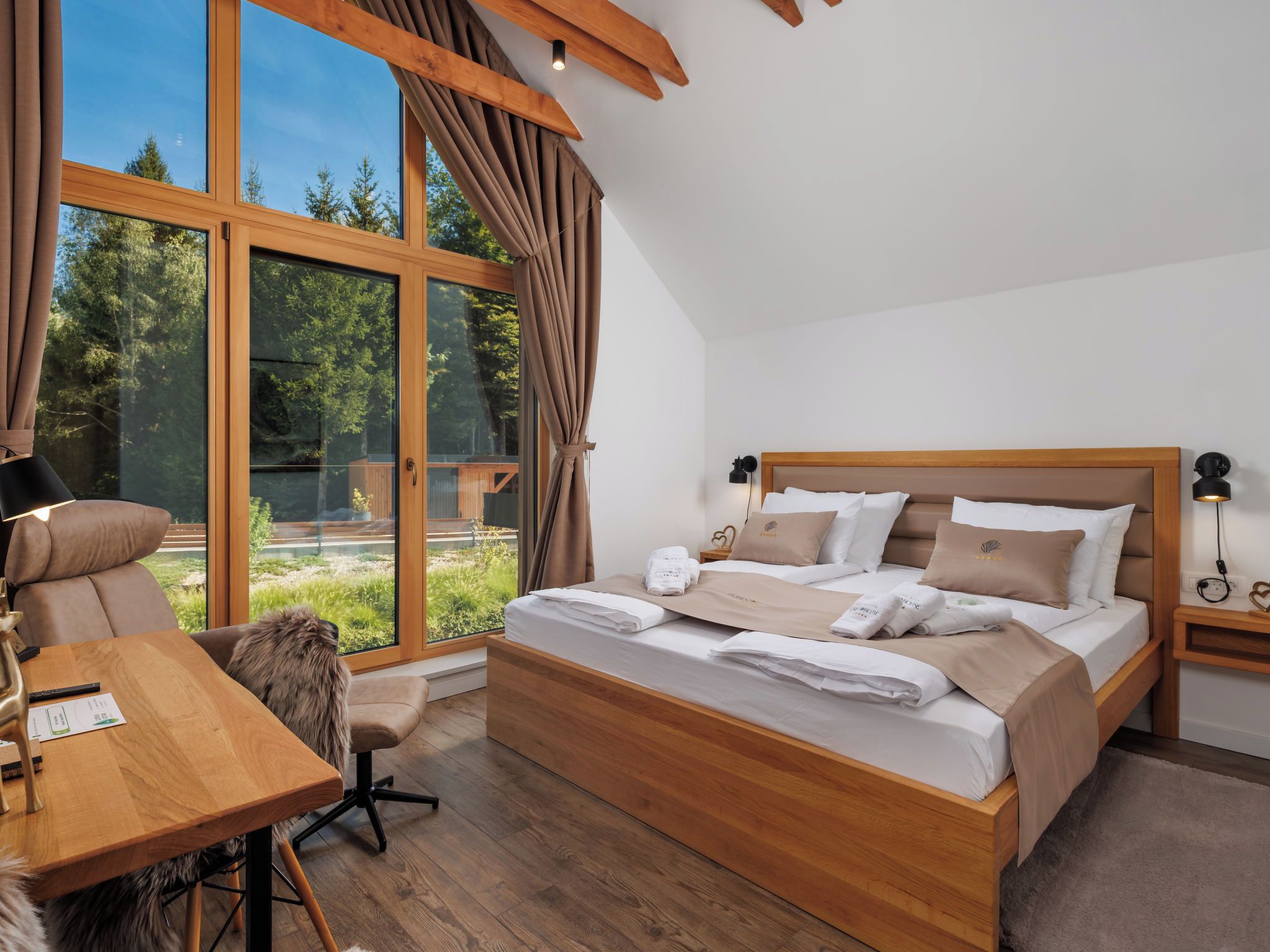 Een moderne slaapkamer met een groot bed, een bureau en uitzicht op de omgeving.