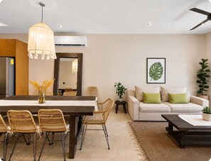 A modern living room with a dining area, featuring a sofa set, a coffee table, and a dining table with chairs. - 5 stars Luxury Retreat  Rooftop Pool Whirlpool tub (tulum)