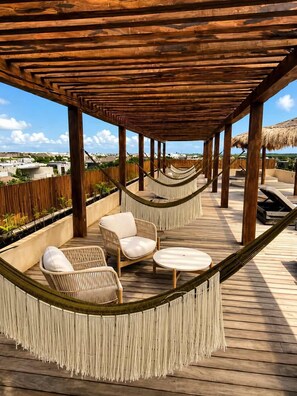 A wooden deck with a hammock, two wicker chairs, and a small table. - 5 stars Luxury Retreat  Rooftop Pool Whirlpool tub (tulum)