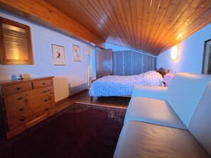 A bedroom with a bed, a dresser, a nightstand, and a window. - Chalet Rezia Appartement/Fewo, Dusche oder Bad, WC, 1 Schlafraum by Interhome (Savognin)