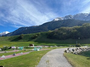 A mountain landscape with a clear sky, a gravel path, and a small building with a green roof. - Tgesa Tgampi T20 Appartement/Fewo, Dusche, WC, 2 Schlafräume by Interhome (Savognin)