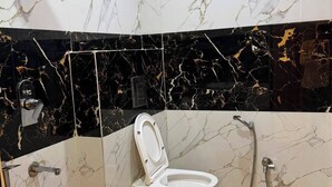Een badkamer met toilet, douche en wastafel.