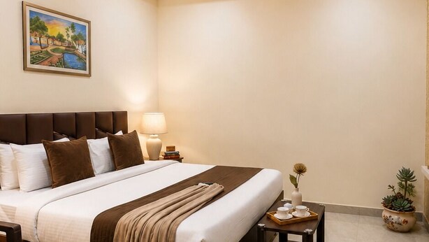 Een hotelkamer met een bed, nachtkastjes, een plafondventilator, een schilderij aan de muur en een kamerplant.