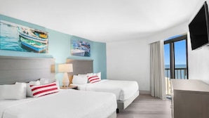 A hotel room with two beds, a TV, a desk, and a window with a view. - Compass Cove Beachfront Escape | Pool Access | Balcony | Hot Tub | Free Parking (Myrtle Beach)