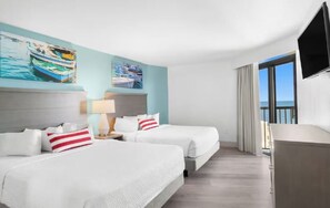 Ett hotellrum med två sängar, en TV, ett skrivbord och ett fönster med utsikt.