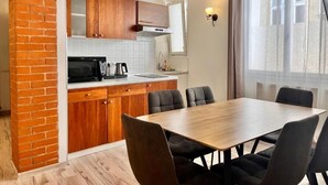 Una cucina con mobili in legno, un forno a microonde e un tavolo da pranzo con sedie.