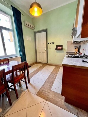 Una cocina con mesa y sillas, estufa y una puerta.