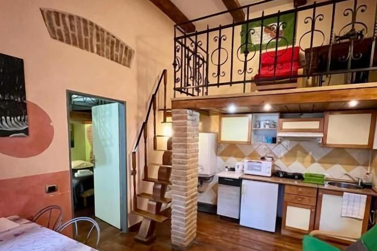 Una cocina compacta con comedor, una escalera y una pequeña sala de estar.