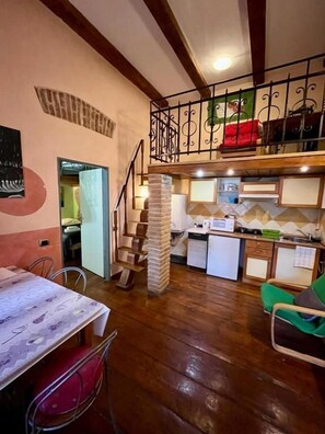Una cocina compacta con comedor, una escalera y una pequeña sala de estar.
