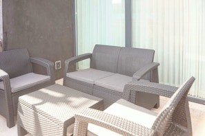A wicker outdoor seating area with a cushioned sofa and two armchairs, a small table, and a bench. - Luxury Condo at Amira District Rooftop Infinity (Tulum Municipality)