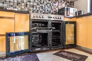 A kitchen with a built-in oven, a microwave, and a coffee maker on the countertop. - Urban Oasis (Nairobi)