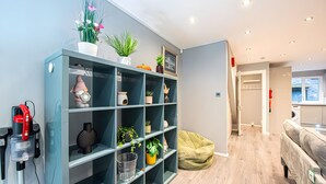 Un espace de vie moderne doté d’une bibliothèque intégrée, d’une machine à café et d’un fauteuil en forme de sac de haricots.