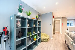 A modern living space with a built-in bookshelf, a coffee machine, and a bean bag chair. - Luxury 4BR House|Contractors • Corporate •Jacuzzi (London)