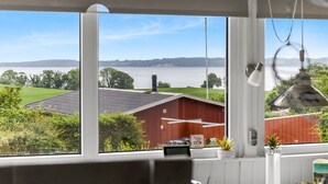Huoneessa on suuri ikkuna, josta avautuu näkymä punaiseen navettaan ja vesistöön.