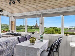 A room with a bed, a table, chairs, and a view of a green landscape through large windows. - "Agla" - 350m from the sea by Interhome (Aabenraa)