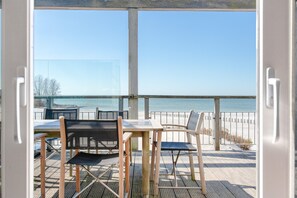 An open deck with a view of the beach and ocean. - Luxury Makkum Beachvilla for 6 (Makkum)