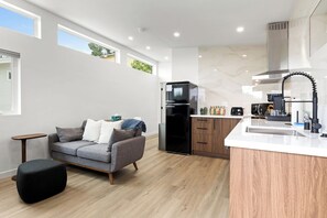 Una cuina moderna amb frigorífic integrat, cafetera i rentaplat.