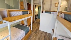 A compact room with bunk beds, a small kitchenette, and a bathroom. - Casa Astral  (Flores)