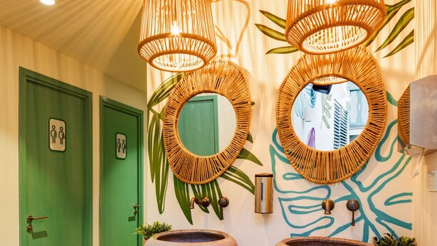 A bathroom with two green doors, a stone sink, and a trash bin. - Casa Astral  (Flores)