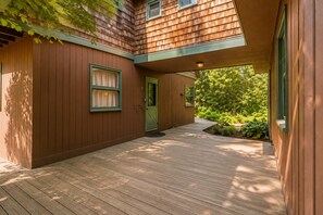 Ein Holzhaus mit überdachter Veranda und einer grünen Tür.