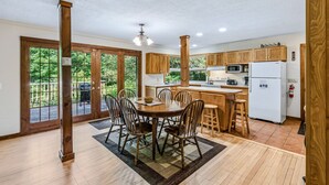 Une cuisine spacieuse avec des meubles en bois, un îlot central et un coin repas avec des chaises.