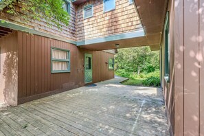 A wooden house with a covered porch, a green door, and a window with curtains. - Spacious Upstairs Apartment Near Stowe Mountain (Stowe)
