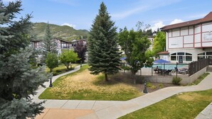 A courtyard with a pool, outdoor seating, and a mountain backdrop. - Villa 2080 1 Bed 1 Bath Full Kitchen in the heart of Midway Utah (Midway)