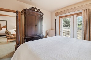 A bedroom with a large bed, a wooden wardrobe, a chair, and a window with blinds. - Villa 2080 1 Bed 1 Bath Full Kitchen in the heart of Midway Utah (Midway)