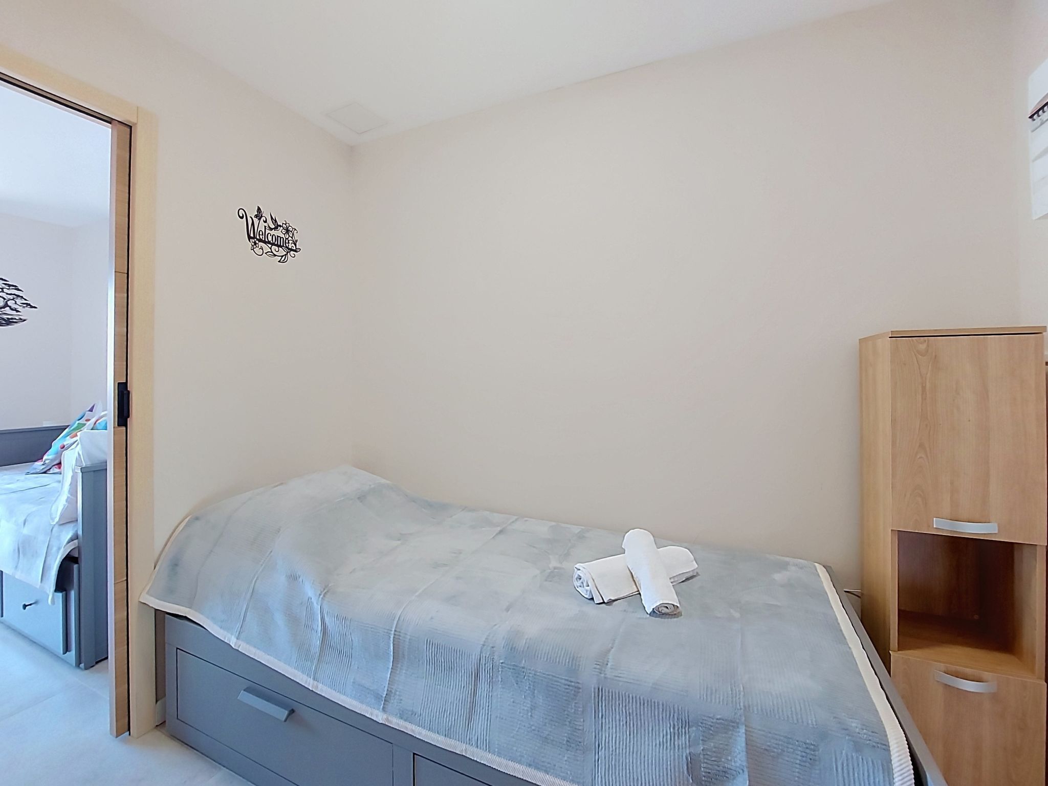 Un dormitorio con cama, armario de madera y decoración en la pared.