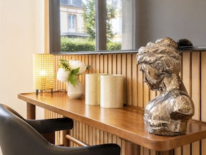 Ein Holztisch mit einer Skulptur, einer Vase mit Blumen und zwei zylindrischen Behältern.