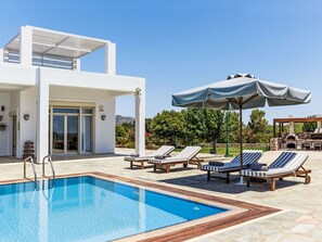 A modern outdoor pool area with lounge chairs and umbrellas. - Belvedere Beachfront by Interhome (Kolympia)
