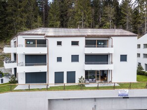 En bygning med flere etager, altaner, store vinduer og et fladt tag.