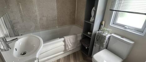 Un baño con bañera, lavamanos e inodoro.