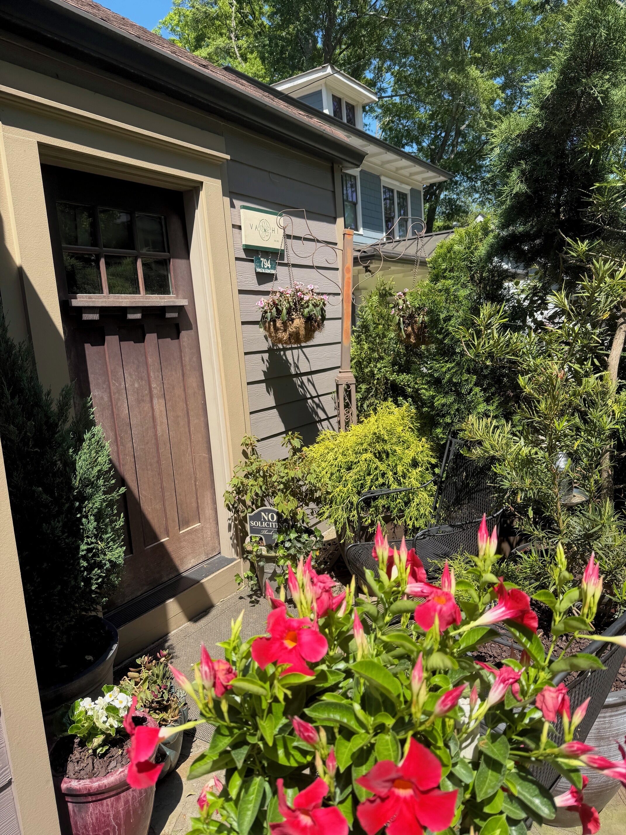 A house with a brown door, a mailbox, and a 'NO Soliciting' sign.