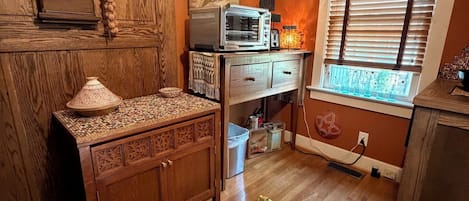 Une cuisine avec des meubles en bois, un four à micro-ondes et un tapis à motifs.