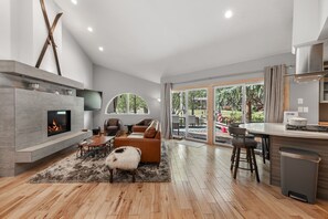 A modern living room with a fireplace, seating area, and a view to the outdoors. - Eagle-Vail Duplex - Golf Front - Near Beaver Creek (Avon)