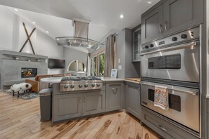 Eine moderne Küche mit Einbauherd, Backofen und Kamin.