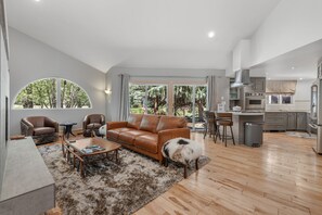 Ein geräumiges Wohnzimmer mit einer Ledersofa, einem Couchtisch und einem flauschigen Teppich.