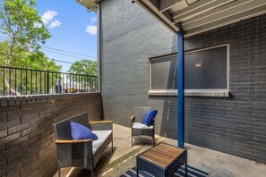A patio with wicker furniture and a window. - 2 Min AT&T Stadium Walk | Cozy & Clean 2BR Apt (Arlington)